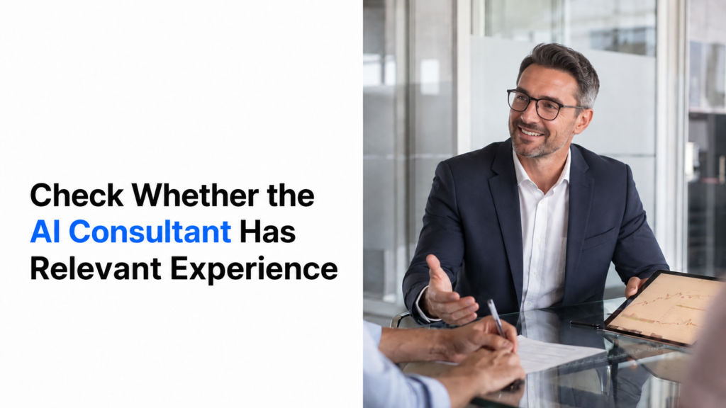 Promotional business graphic with the headline “Check Whether the AI Consultant Has Relevant Experience” on the left, with “AI Consultant” highlighted in blue. On the right, a smiling man in glasses and a navy suit sits at a glass conference table in a modern office, gesturing during a meeting while another person takes notes and a tablet displays a chart.